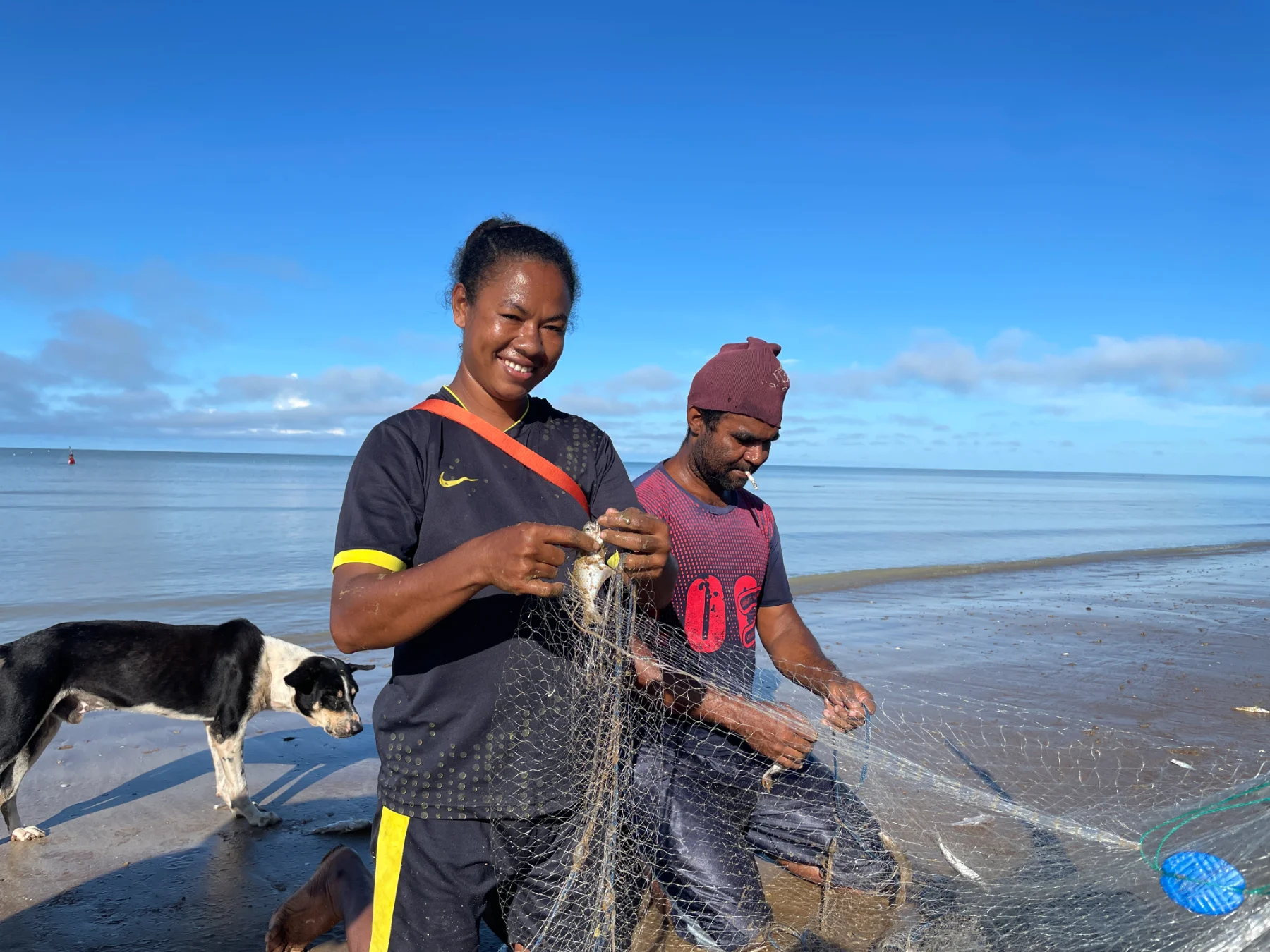 Mama Ester, a woman champion of the BERDAYA program from Kampung Matara, Merauke, works with her husband to pull in a fishing net along the coast. Women like her take part in women's life skills and leadership education while developing coastal-based livelihoods for their families.