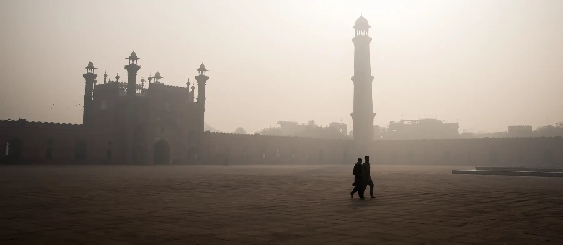 A group of men walk in to visit the Badshahi Mosque which is a Mughal era mosque in Lahore, Pakistani province of Pujab