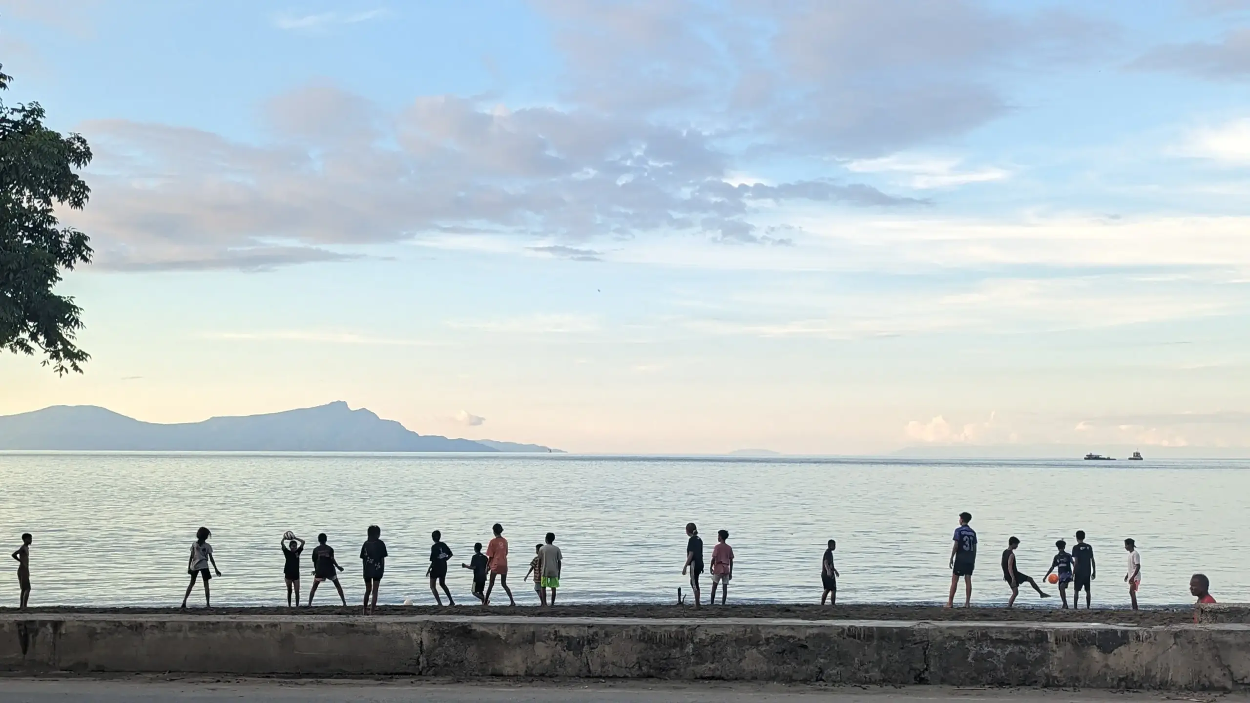 Children play along the shoreline in Dili as evening settles over Timor-Leste.