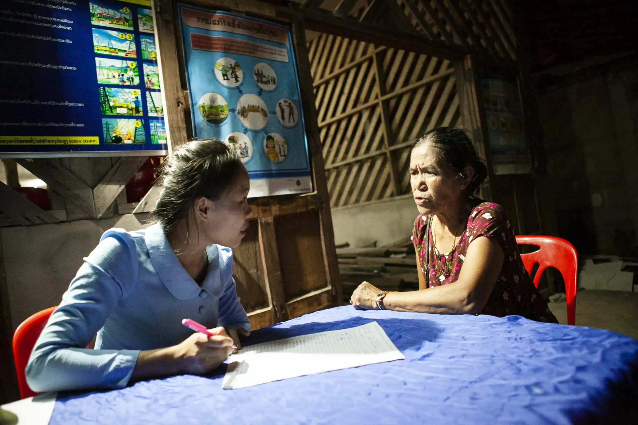 A legal worker records details as she meets one-on-one with a woman in a rural village in Lao PDR, part of the Access Justice Program to bring individual guidance and support directly to those navigating disputes in underserved communities.
