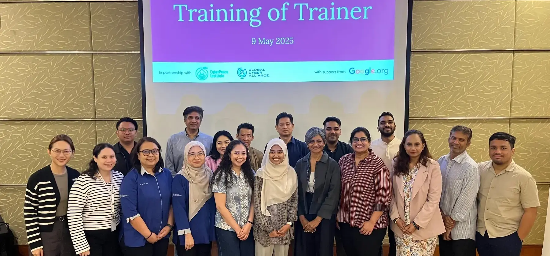 Group photo of participants posing together at the APAC Cybersecurity Fund MY Training of Trainer event on May 9, 2025 in Malaysia, in front of a presentation screen.