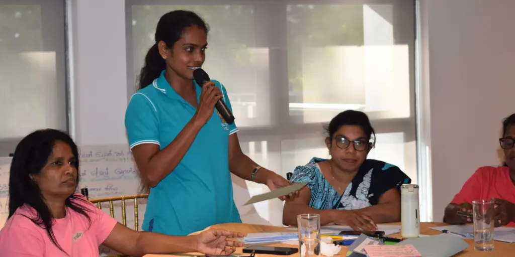 A participant sharing feedback at a Training of Trainers program on women's leadership for Community Women's Collectives.